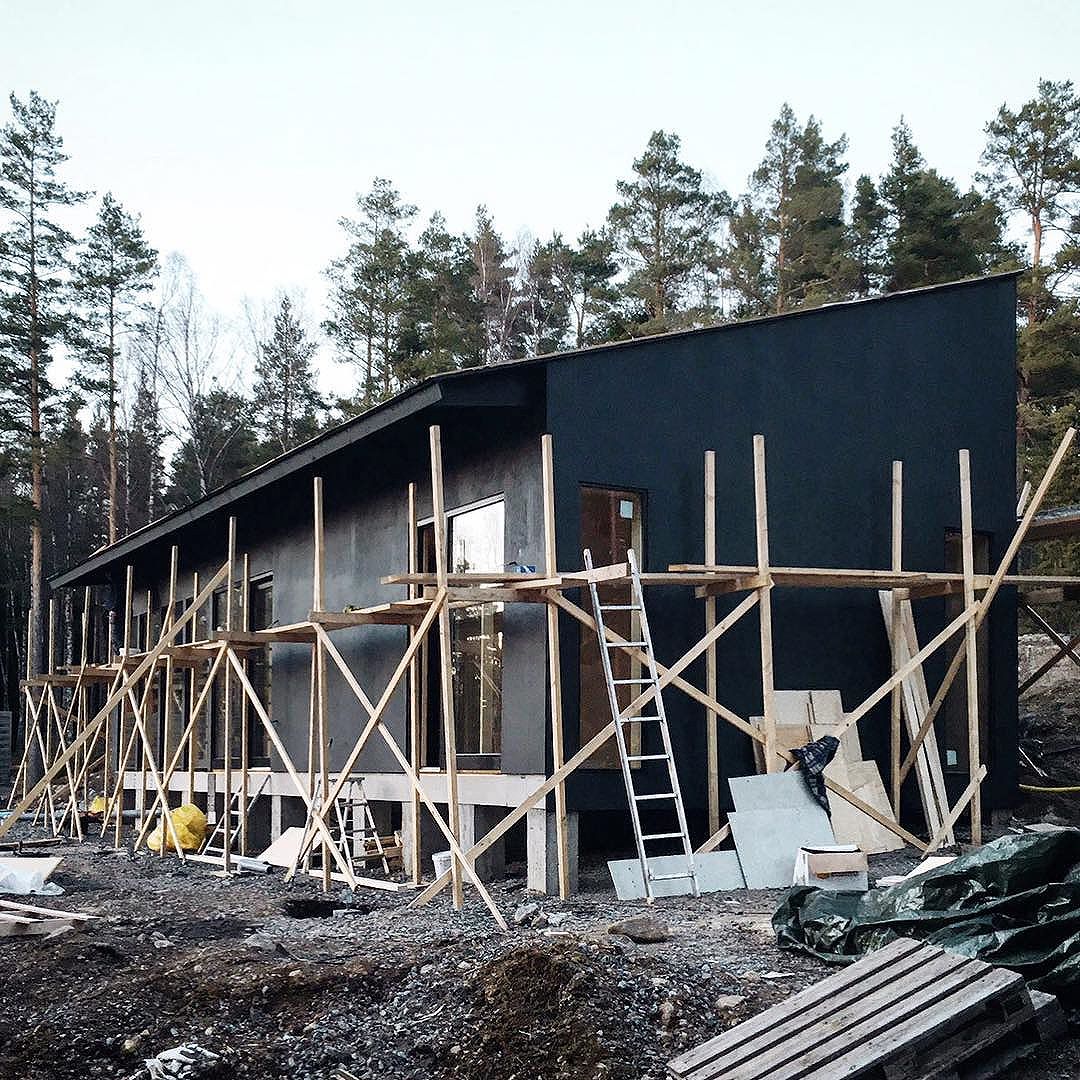 Private summer house beginning to reveal its final appearance with the first coat of black paint.